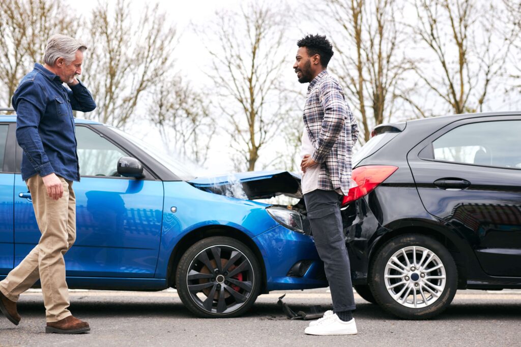 2 men talking to each other after getting into a car accident